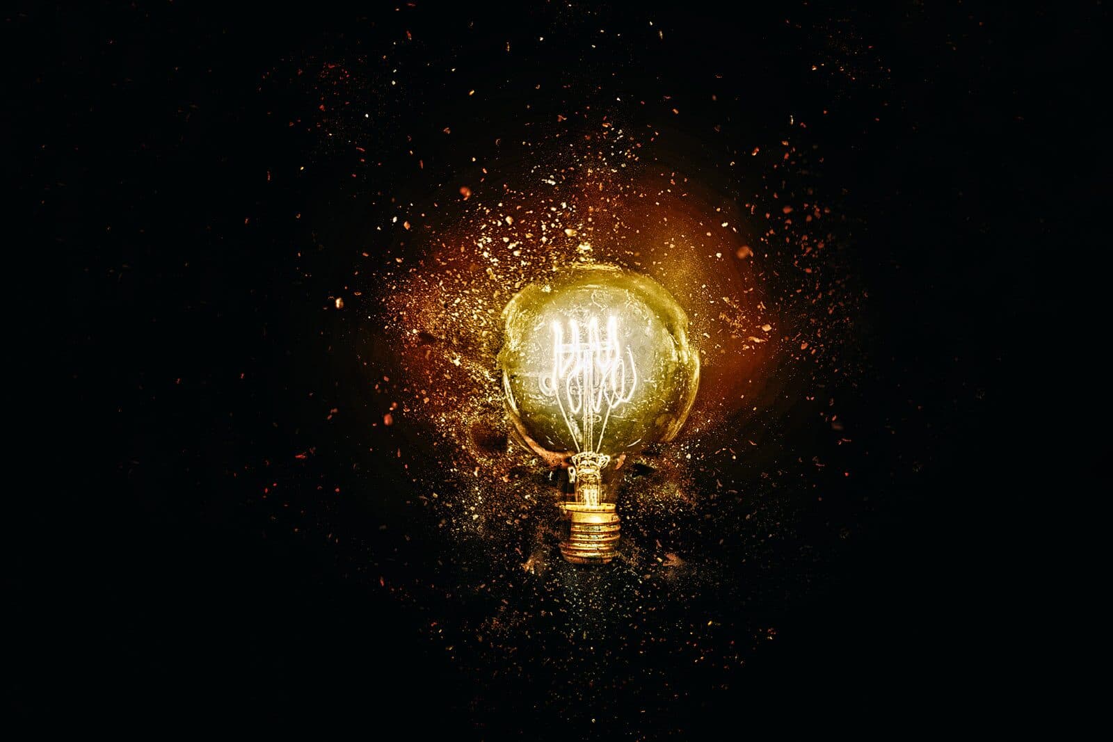 Bombilla encendida entre partículas doradas